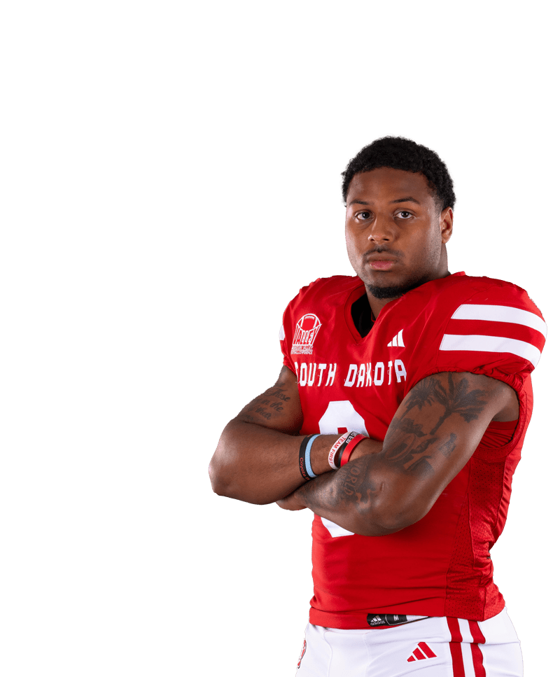 Football player tossing football in the air