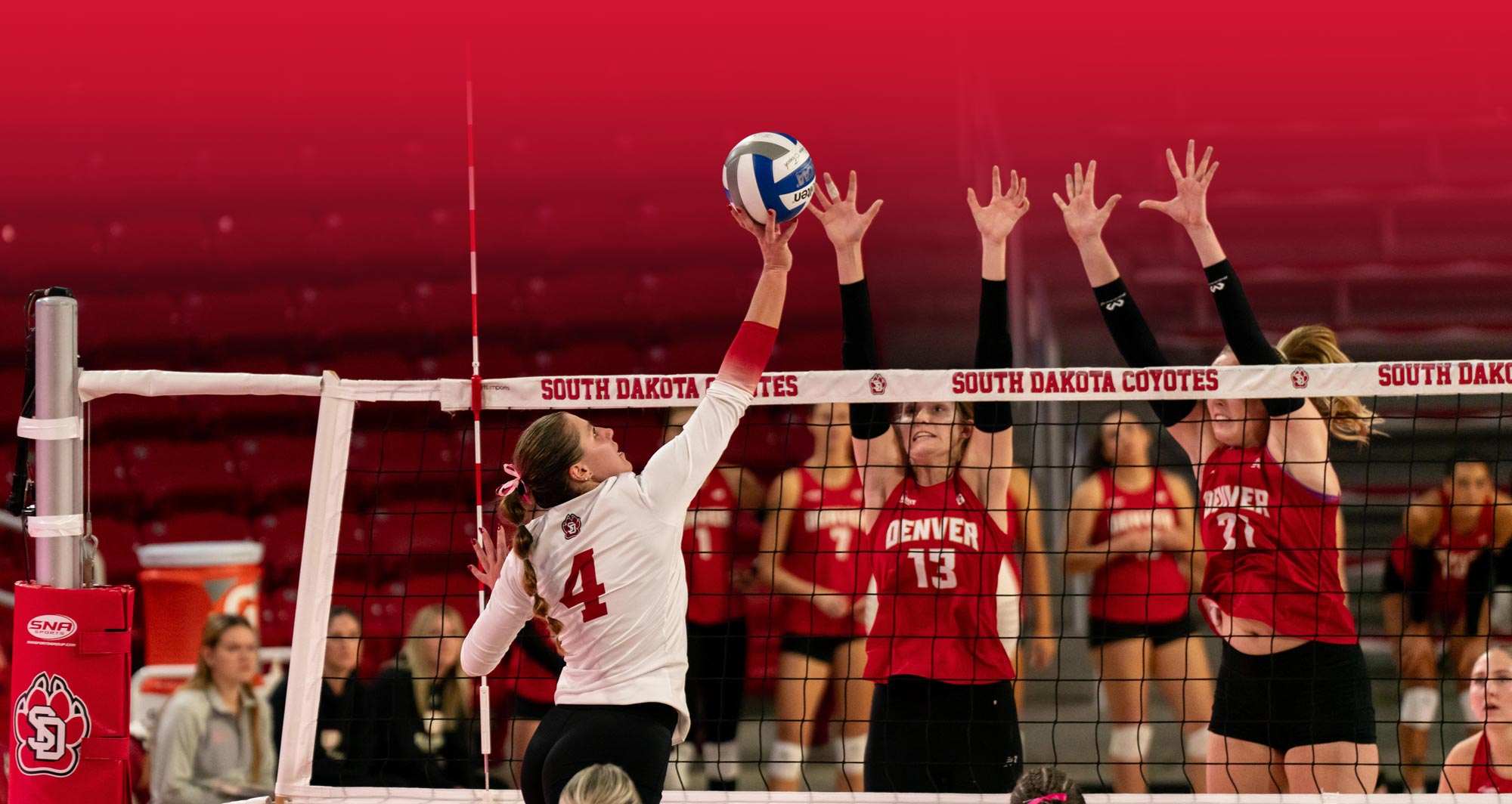 Volleyball players jumping at the net