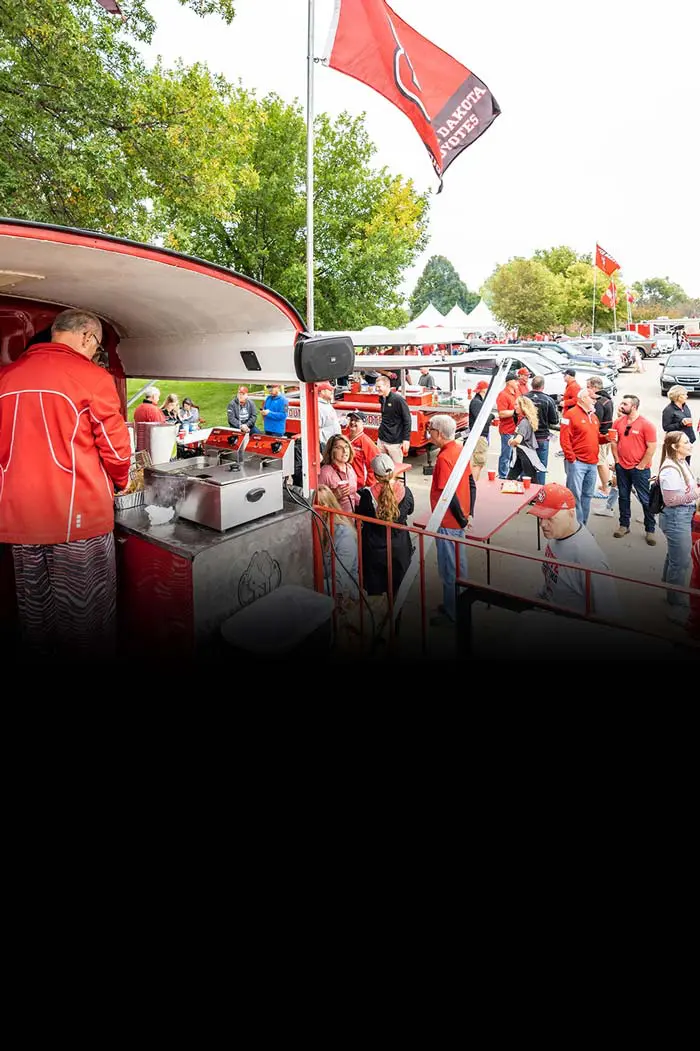 student-athletes in a group cheering with hands up