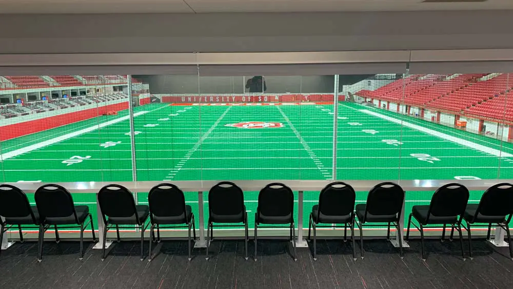 View of empty field from behind a row of seats