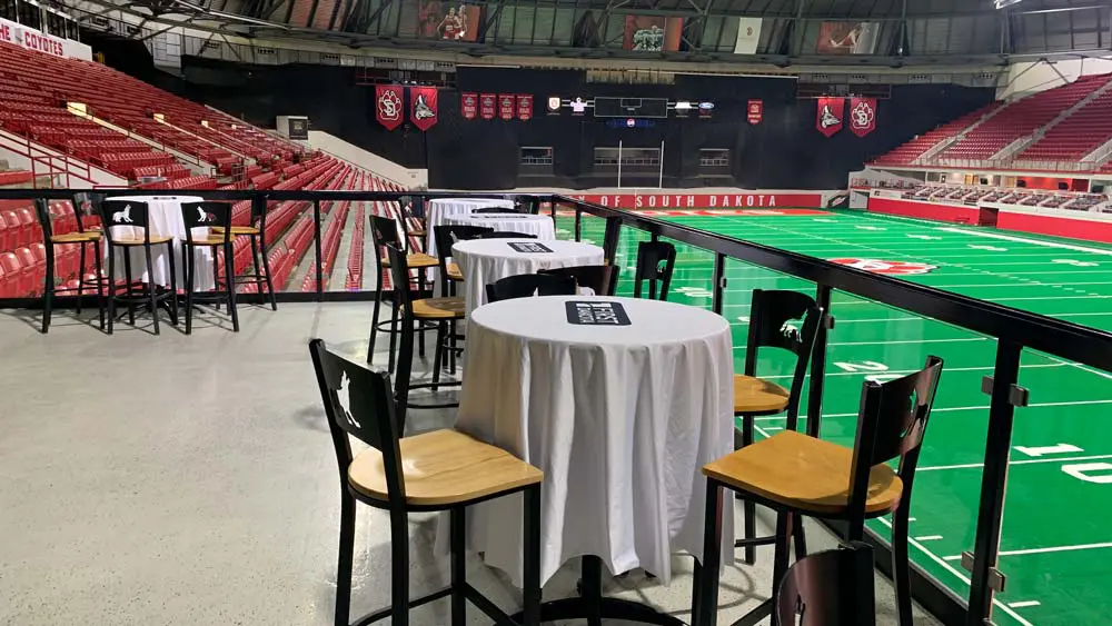 View of field behind empty tables and chairs